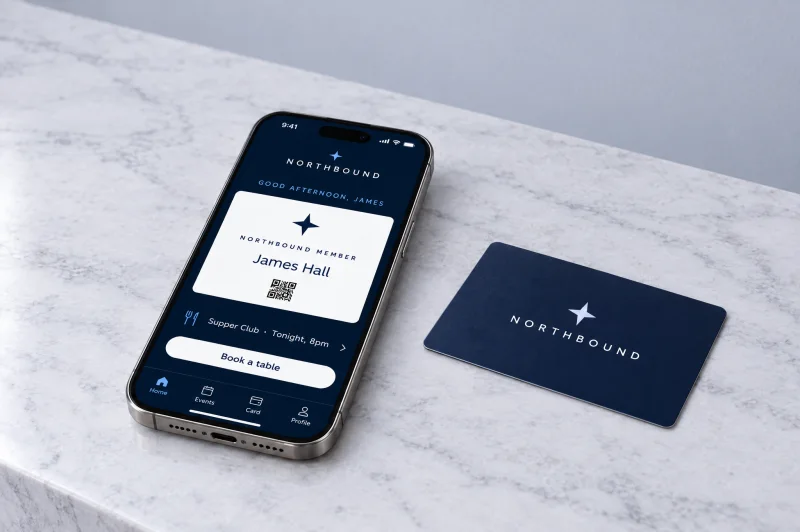 Illustrative Northbound members' club app on an iPhone lying on marble beside a navy member card